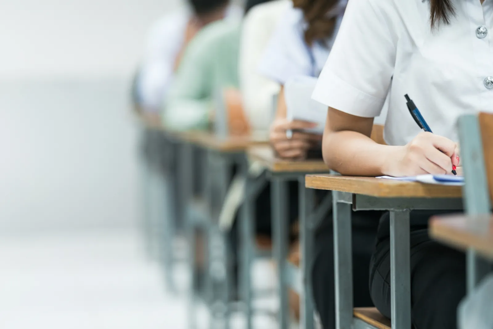 Candidats assis à leurs tables pendant une épreuve écrite