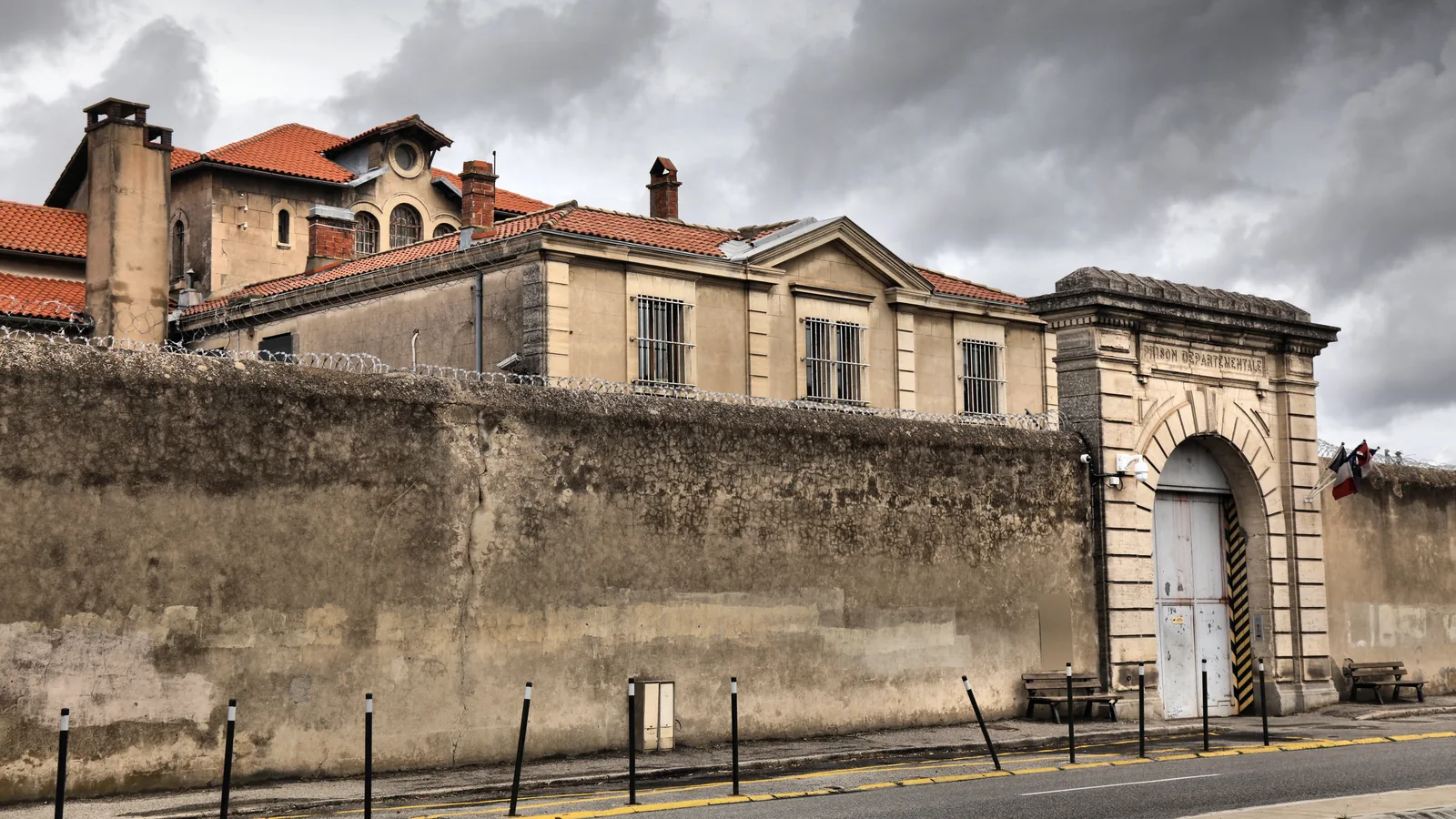 Façade, portail et mur d’enceinte d’un établissement pénitentiaire en France.
