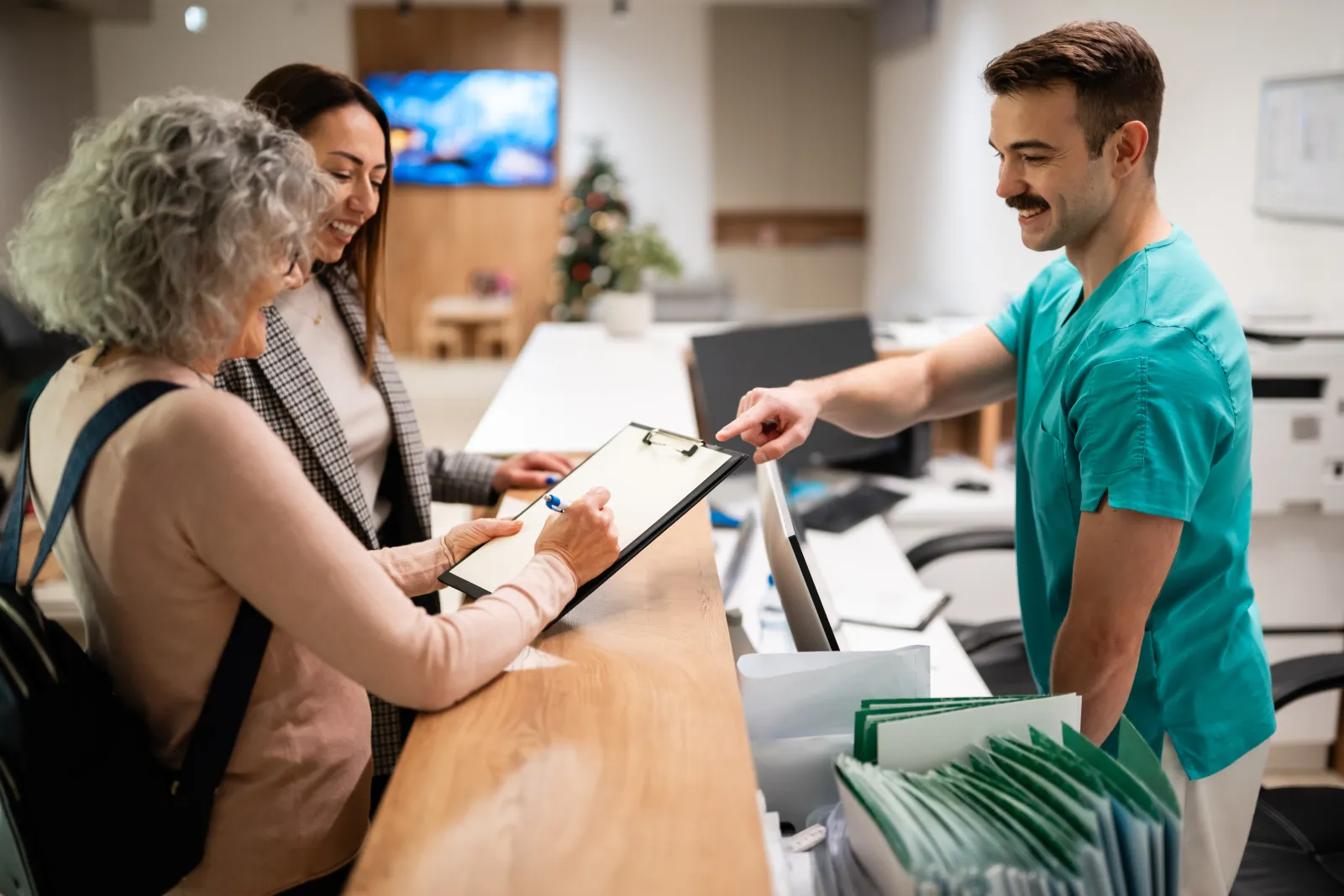 Une personne remplit un formulaire au comptoir d’accueil d’un établissement de santé.