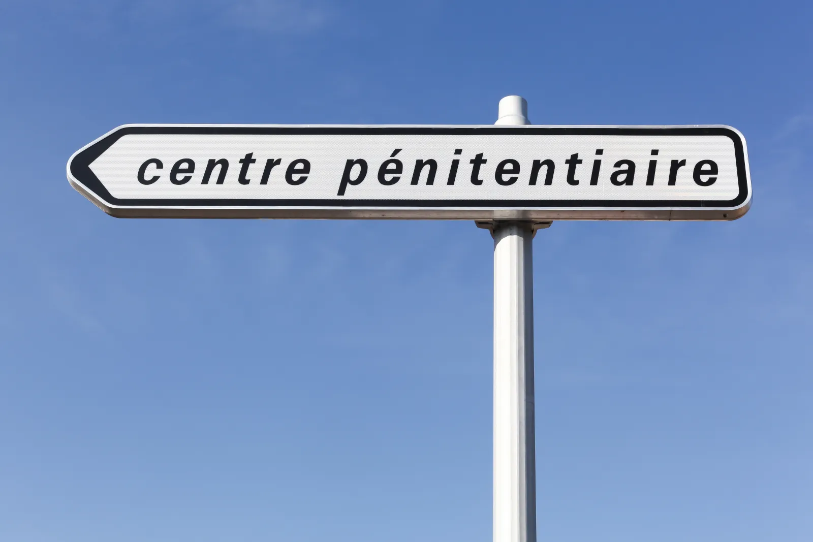 Panneau directionnel indiquant un centre pénitentiaire.