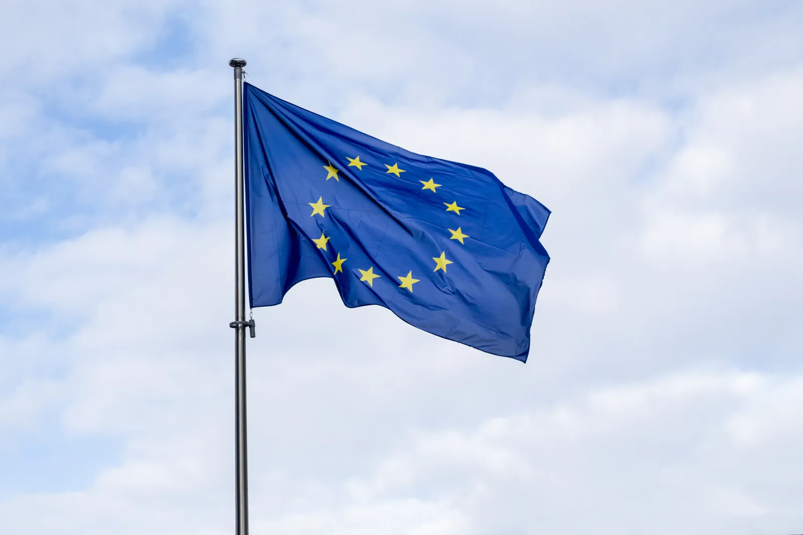 Le drapeau de l’Union européenne flotte au sommet d’un mât.
