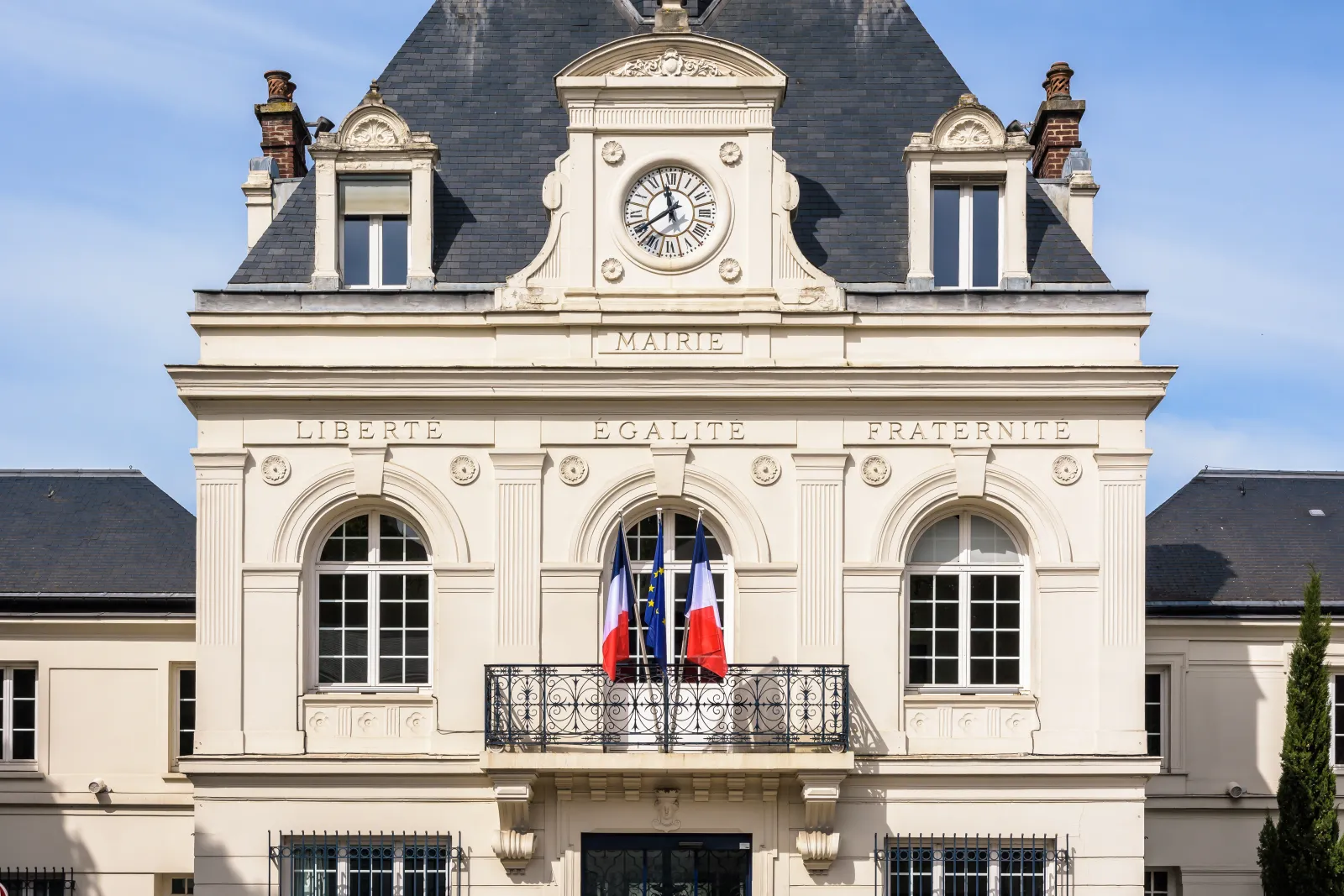 Façade d’une mairie française avec les drapeaux français et européen.